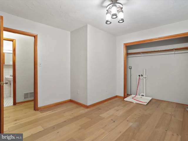 clothes washing area with light hardwood / wood-style flooring