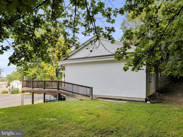 view of property exterior featuring a yard and a wooden deck