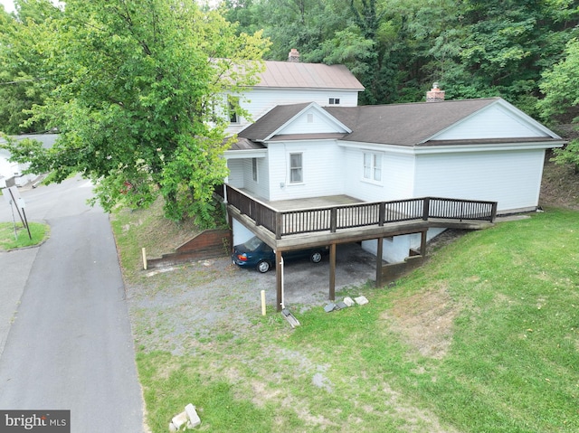 rear view of house featuring a wooden deck and a yard