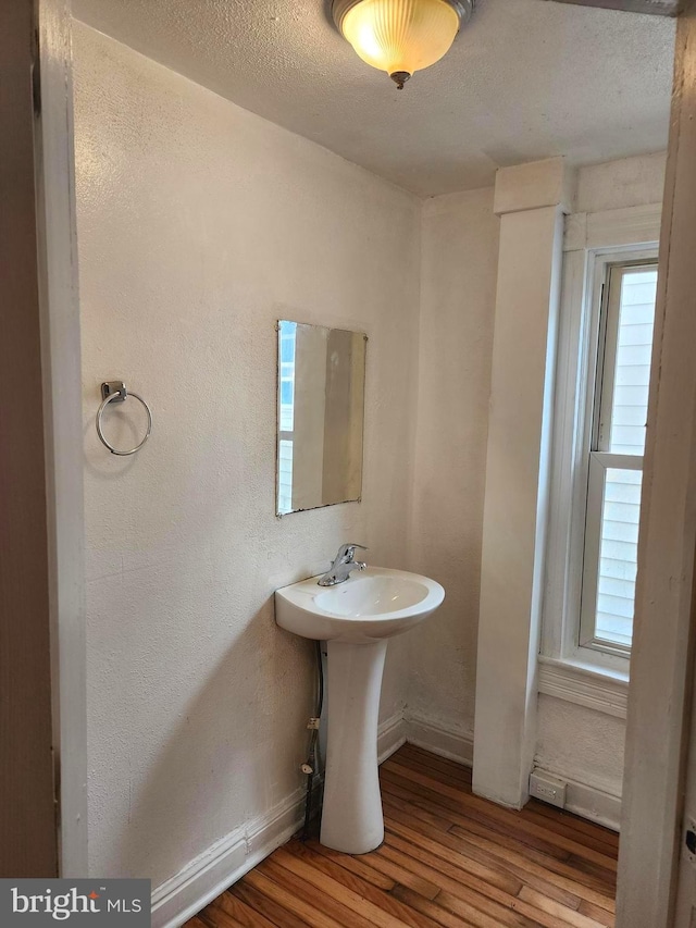 bathroom featuring a textured ceiling and wood-type flooring