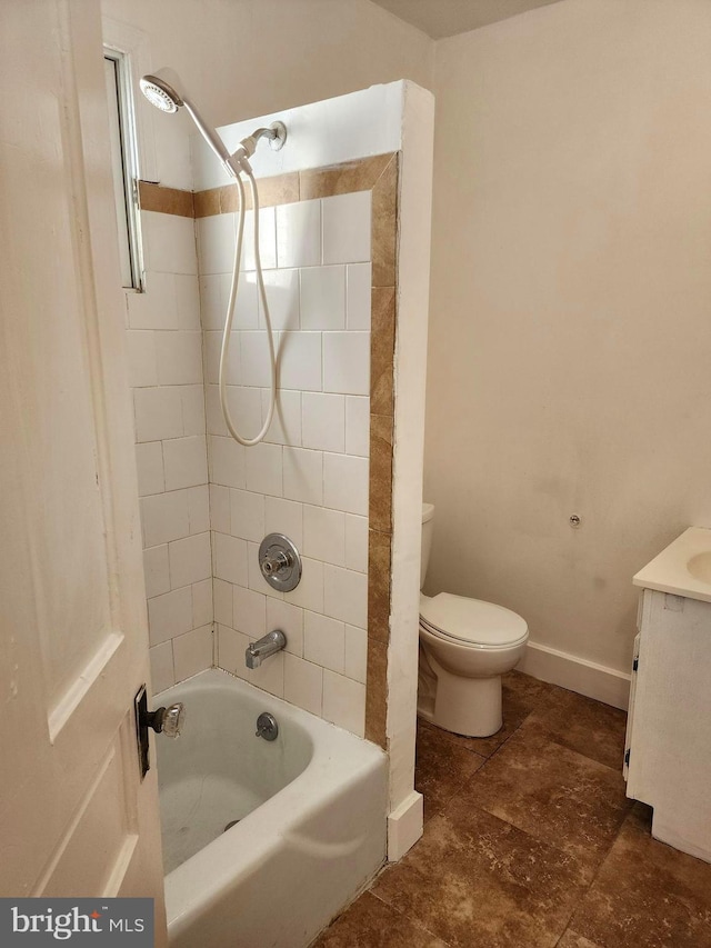 full bathroom featuring tile patterned flooring, toilet, tiled shower / bath, and vanity