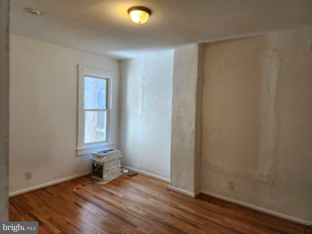 unfurnished room featuring wood finished floors and baseboards