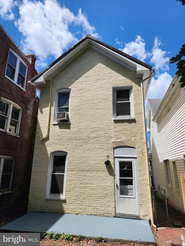 rear view of house featuring cooling unit and brick siding