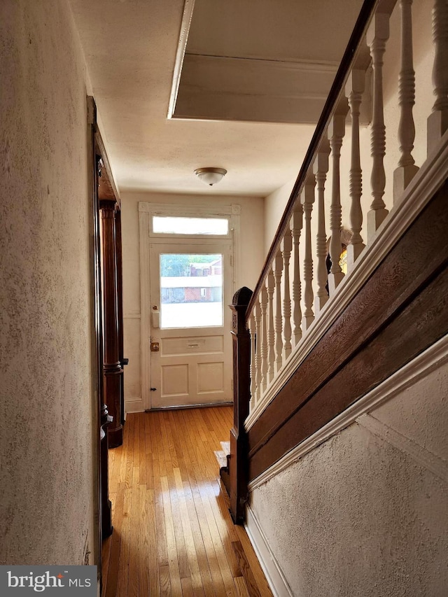 stairs with a textured wall and wood finished floors