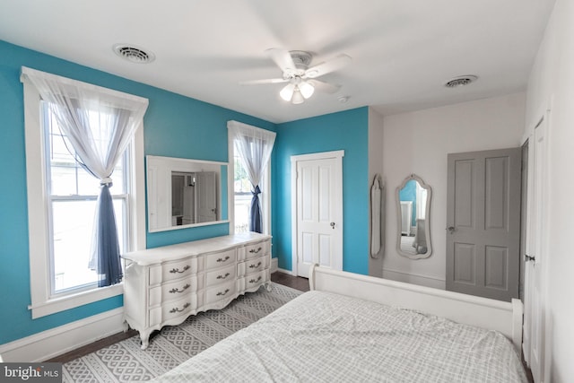 bedroom featuring ceiling fan, light wood-type flooring, a closet, and multiple windows