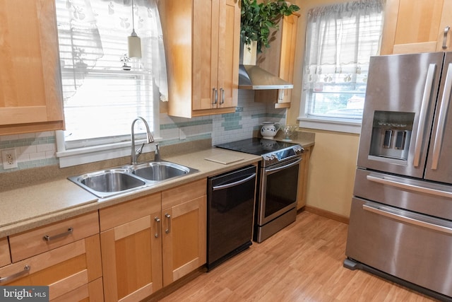 kitchen featuring stainless steel appliances, sink, light hardwood / wood-style floors, and decorative backsplash