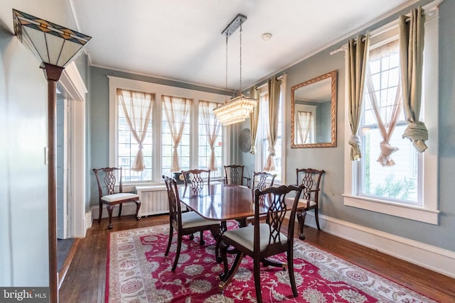 dining area with dark wood-type flooring and ornamental molding