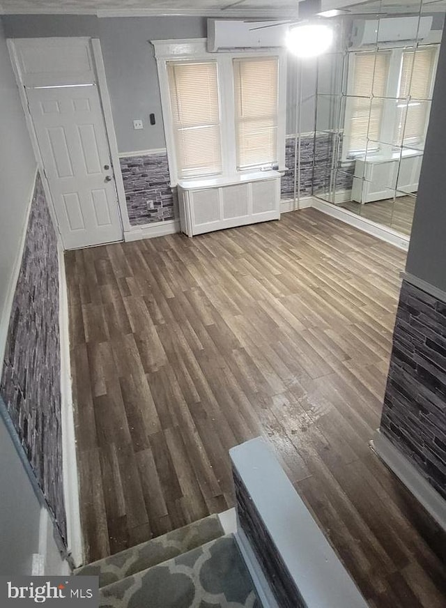 unfurnished living room featuring crown molding and hardwood / wood-style floors