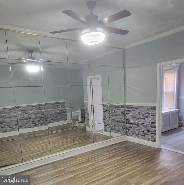 bathroom featuring tile walls, ceiling fan, hardwood / wood-style floors, and crown molding