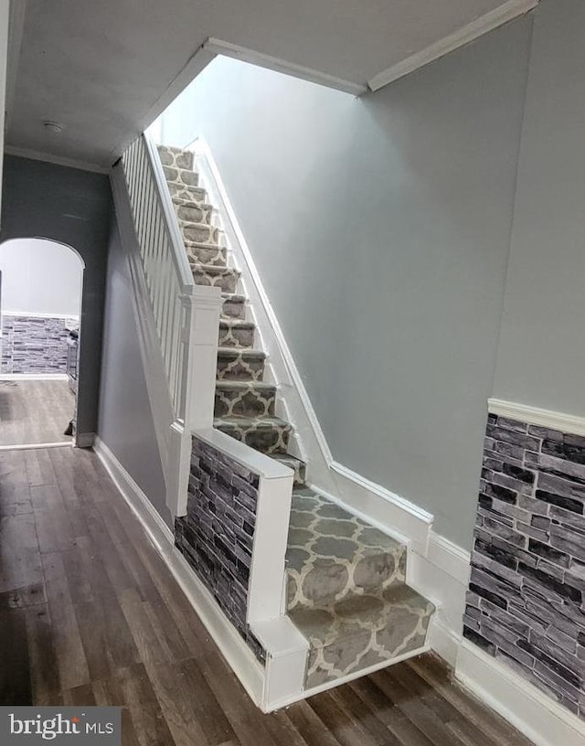 stairs with ornamental molding and wood-type flooring