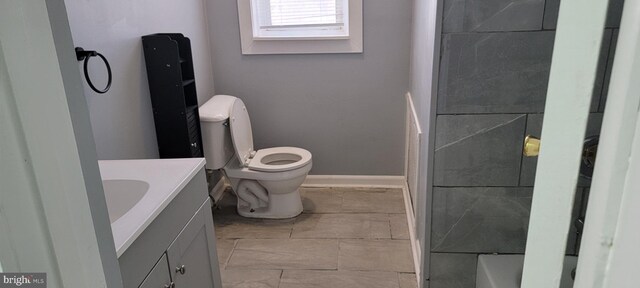 bathroom with a shower, vanity, and toilet