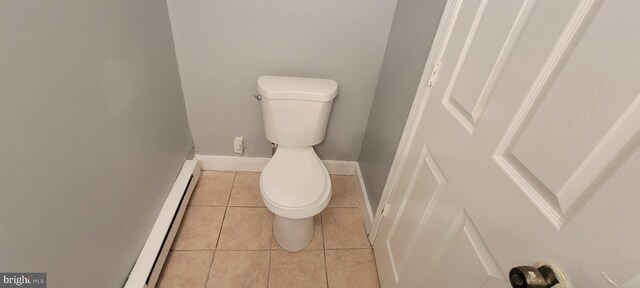 bathroom with toilet, a baseboard heating unit, and tile patterned floors