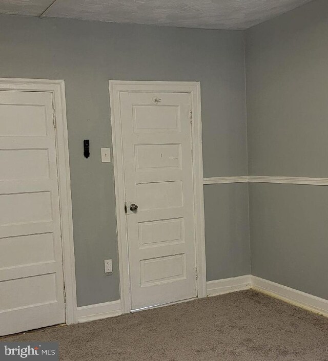 carpeted empty room with a textured ceiling