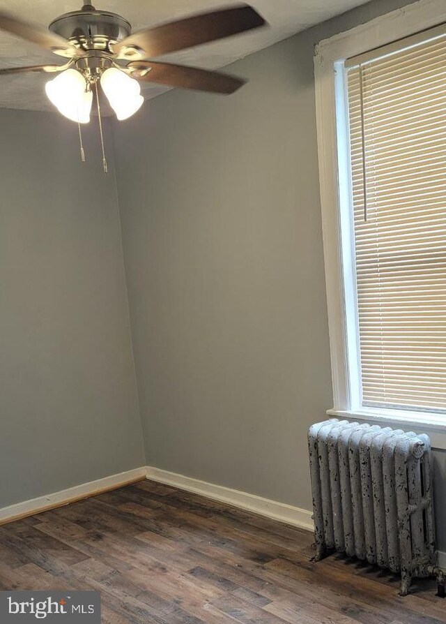 unfurnished room with radiator, ceiling fan, and dark hardwood / wood-style floors