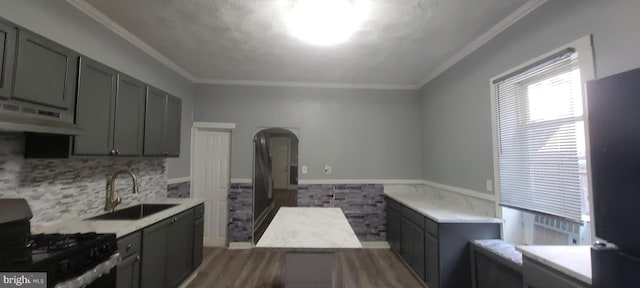 kitchen with black gas stove, ornamental molding, sink, range hood, and dark hardwood / wood-style flooring