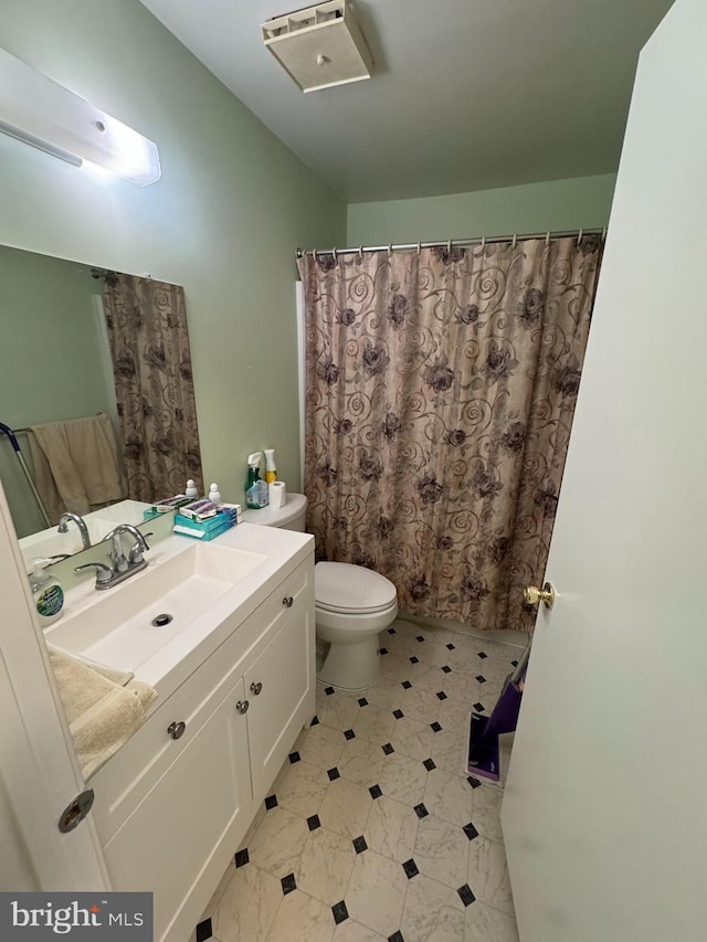 bathroom featuring tile patterned flooring, toilet, and vanity