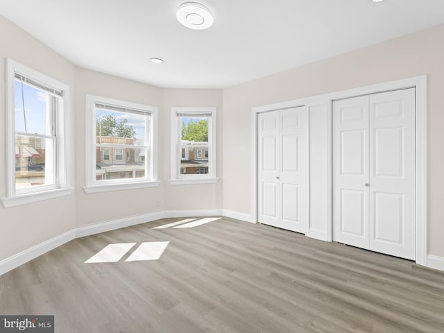 unfurnished bedroom featuring two closets and hardwood / wood-style flooring