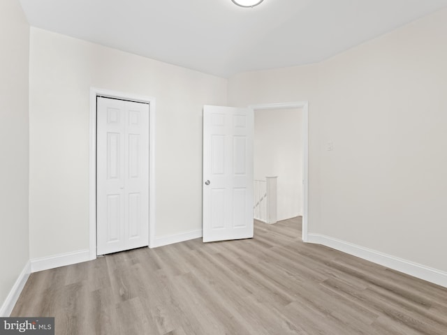 unfurnished bedroom with a closet and light wood-type flooring