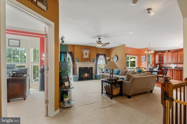 living room with ceiling fan with notable chandelier and light carpet