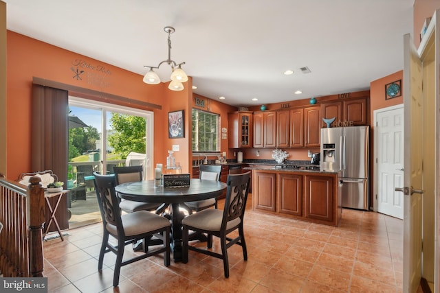 dining room with light tile patterned floors and a notable chandelier