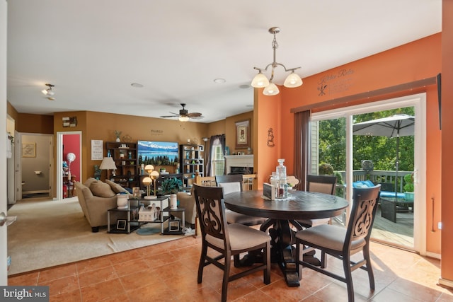 dining area featuring ceiling fan with notable chandelier and light tile patterned floors