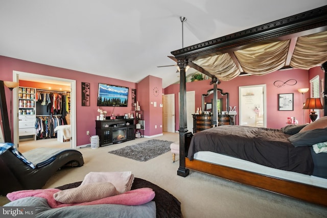 bedroom with vaulted ceiling, a closet, carpet, and a walk in closet