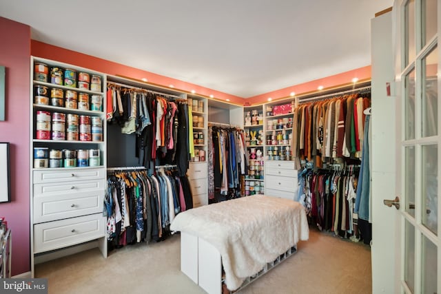 spacious closet featuring light colored carpet