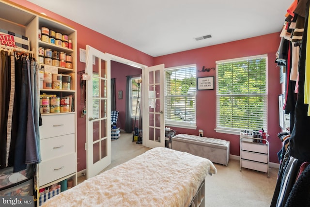 bedroom with french doors and light carpet