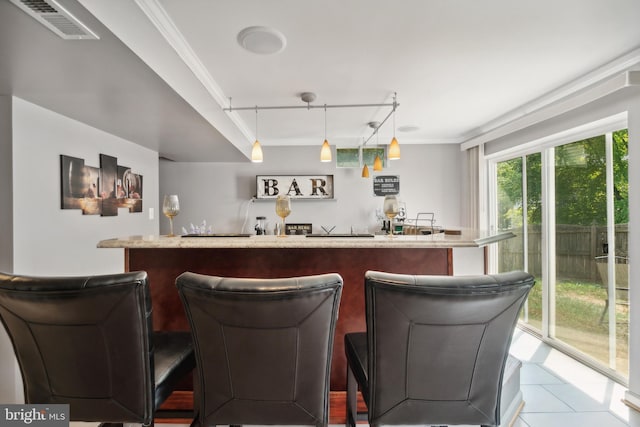 bar featuring crown molding, rail lighting, tile patterned floors, and pendant lighting