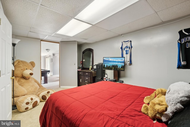 bedroom with carpet floors and a drop ceiling