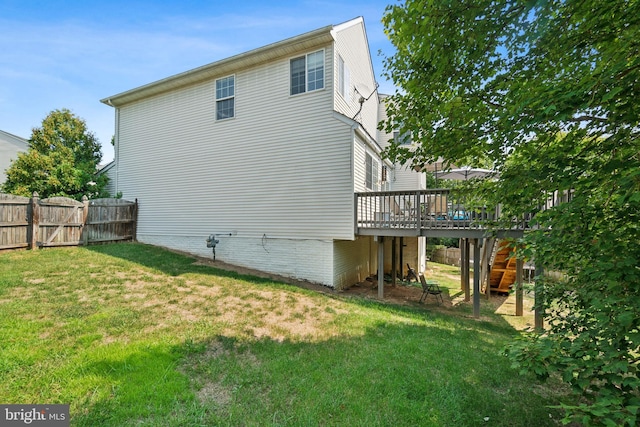 rear view of house with a deck and a lawn