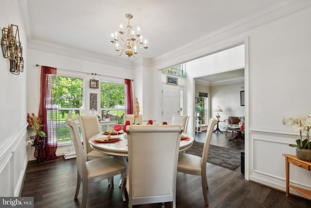 dining space featuring dark wood-type flooring, crown molding, and a chandelier