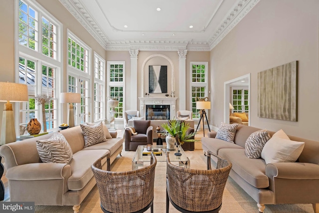 living room with a high ceiling, a fireplace, and crown molding