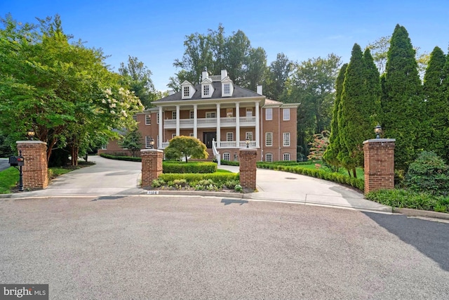 neoclassical / greek revival house featuring covered porch and a chimney