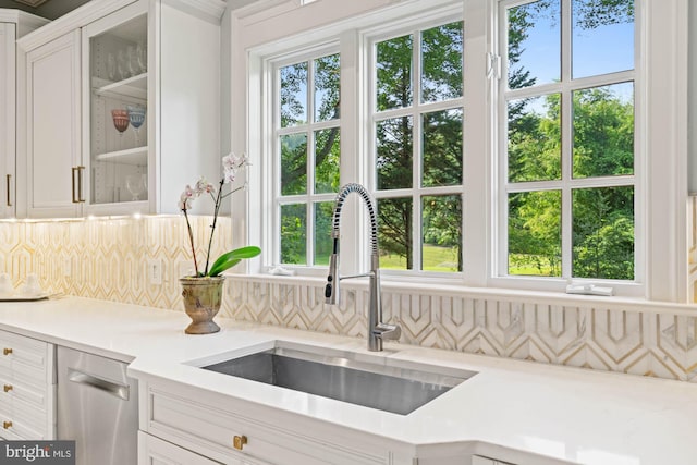 kitchen featuring light countertops, a sink, and white cabinetry