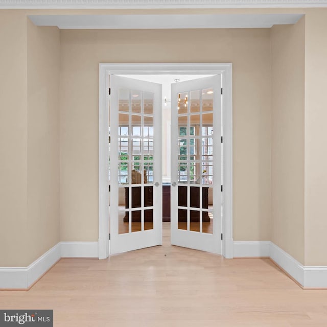 entryway featuring french doors, wood finished floors, and baseboards