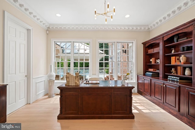 office space with a chandelier, a wainscoted wall, crown molding, and light wood finished floors