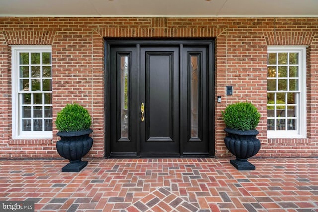 doorway to property with brick siding