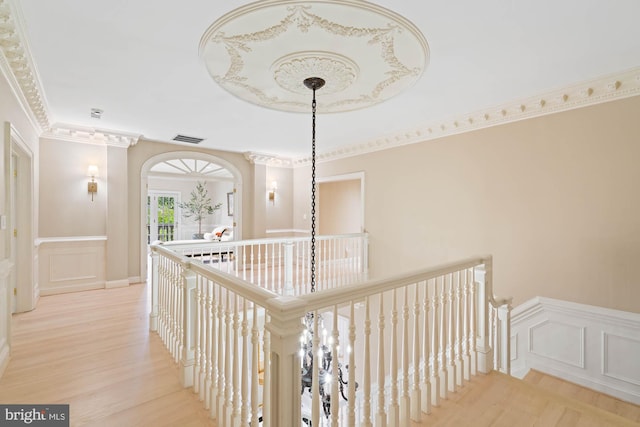 corridor featuring ornamental molding and light hardwood / wood-style floors