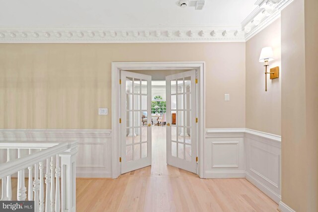 doorway with ornamental molding, french doors, and light hardwood / wood-style floors