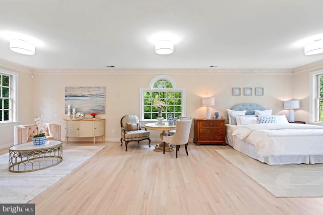 bedroom with multiple windows, ornamental molding, and wood finished floors