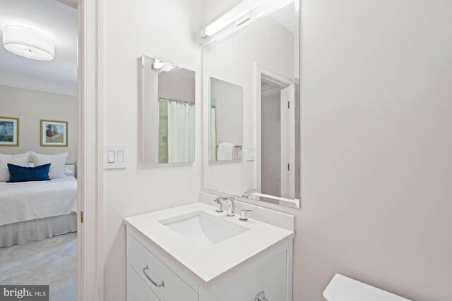 bathroom featuring ornamental molding, vanity, and toilet