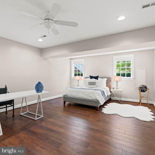 bedroom featuring baseboards, multiple windows, and hardwood / wood-style floors