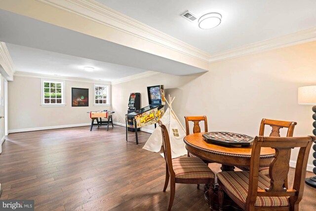 dining area with ornamental molding and dark hardwood / wood-style flooring