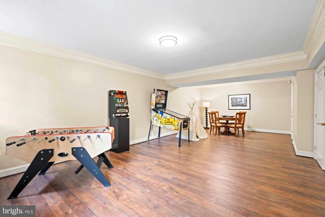 playroom featuring ornamental molding and dark hardwood / wood-style flooring