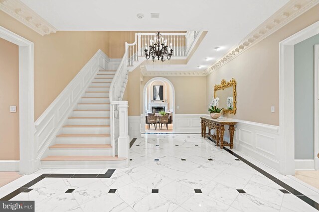 foyer featuring crown molding and a chandelier