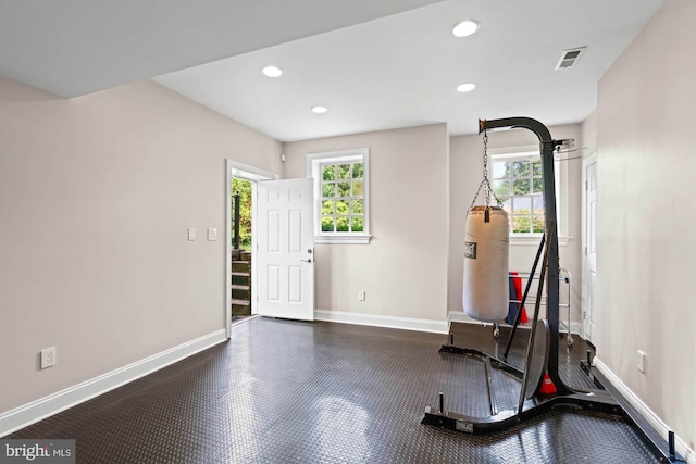 exercise room featuring a healthy amount of sunlight, visible vents, and baseboards