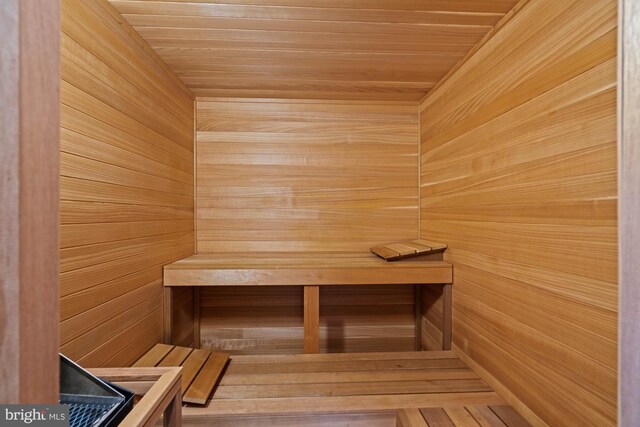 view of sauna with wooden ceiling and wooden walls