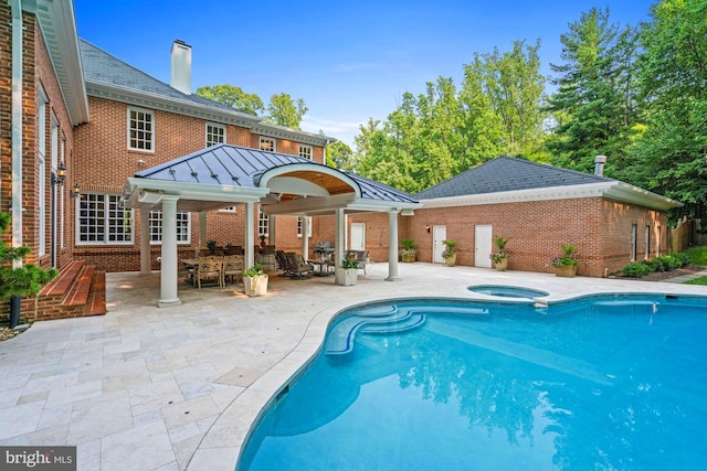 view of pool featuring a patio area and an in ground hot tub