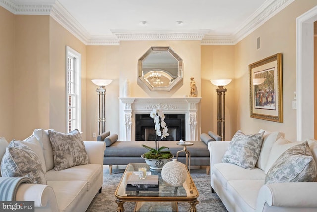 living room featuring ornamental molding, a fireplace, and a notable chandelier